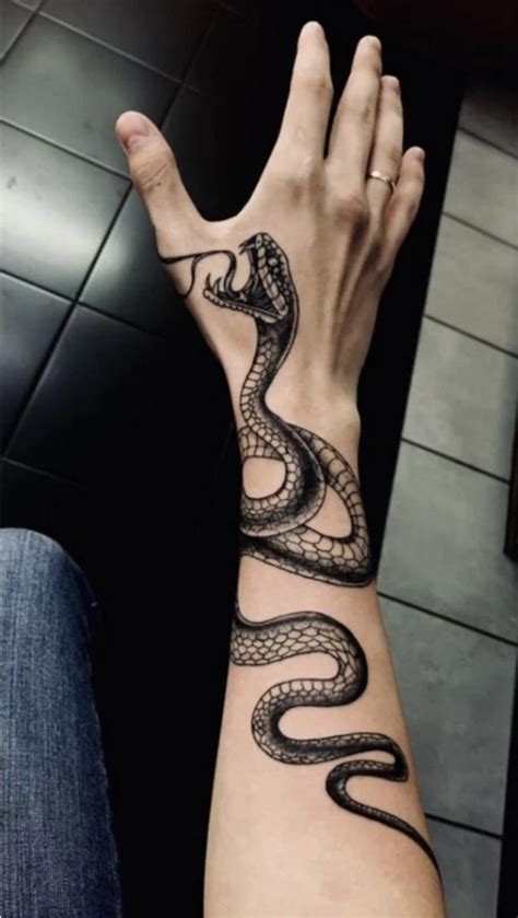 This Tattoo Tells A Story Of Survival And Strength The Snake Biting The Hand Symbolizes The Battles We Face In Life Moments Of Pain Challenge And Resilience But With Every Bite Comes Wisdom
